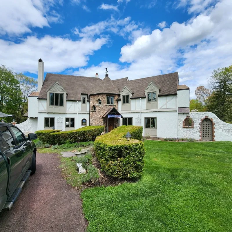 Renovated facade of a large two-story home after extensive rot repair on exterior trim and window frames