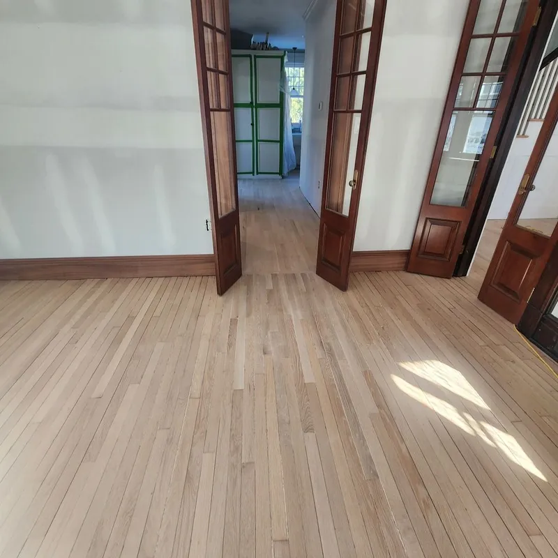 The floor after sanding to blend the old and new surfaces. The repaired section is hardly recognizable as different from the original flooring.